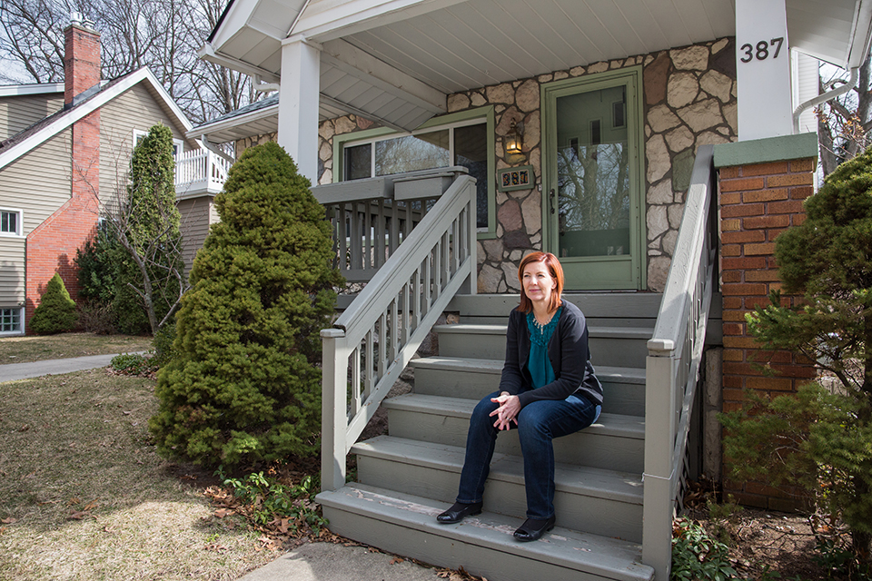 Melanie Piana, Ferndale council member and affordable housing advocate, sits on the porch of her home in Ferndale, Michigan.