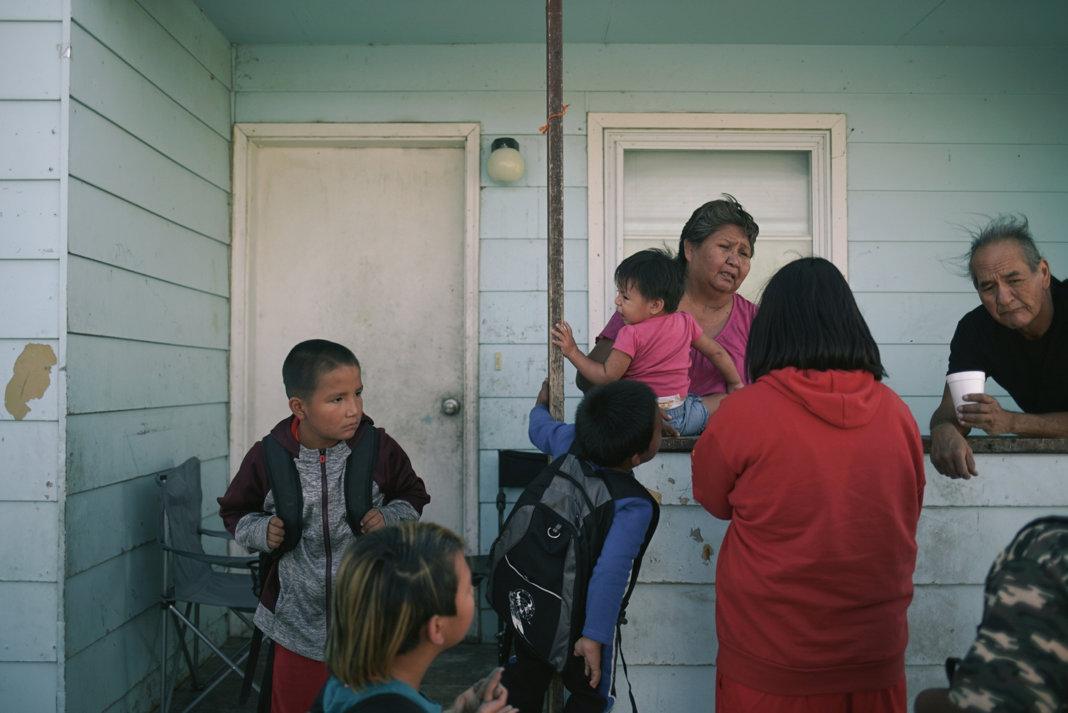 Elsie greets her grandchildren, whom she raises, as they come home from school. 