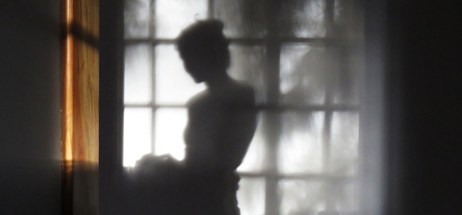 Woman stands in front of window