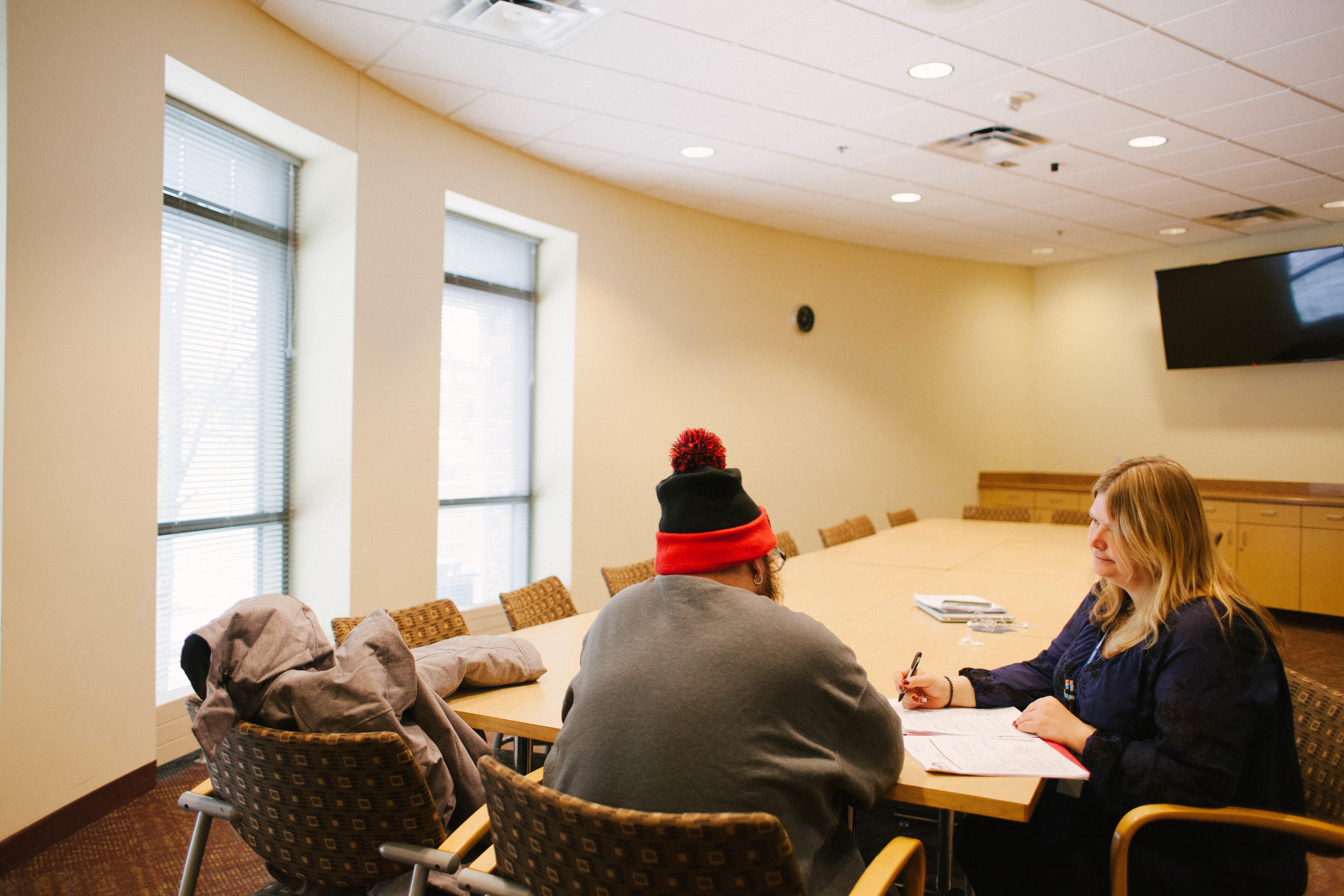 Shellie Rowe, family centers manager at Neighborhood House, meets with a man struggling to pay rent at the organization’s Crisis Clinic pilot.