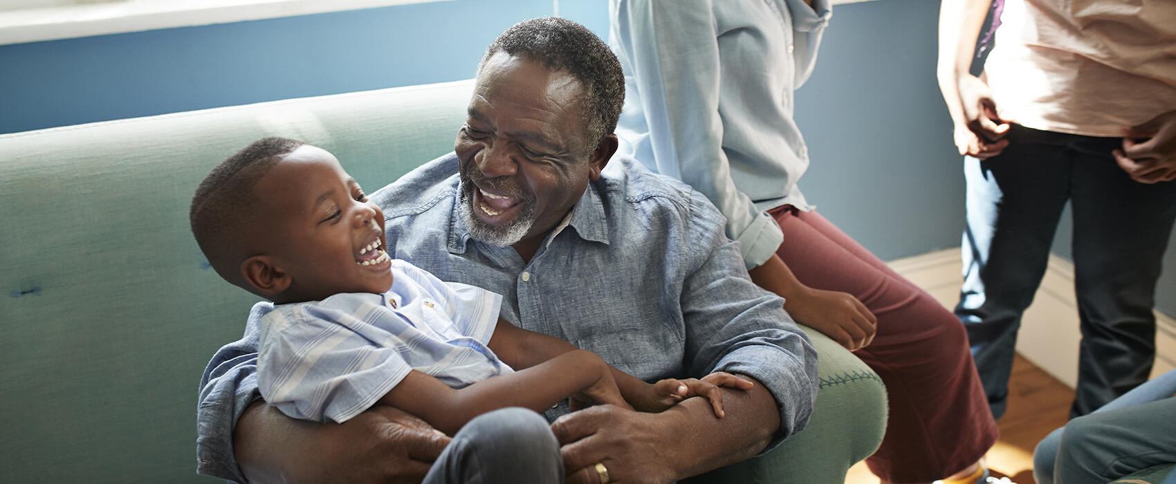 Happy elderly man playing with grandson