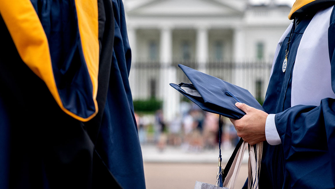 Students from George Washington University wear their graduation gowns outside of the White House