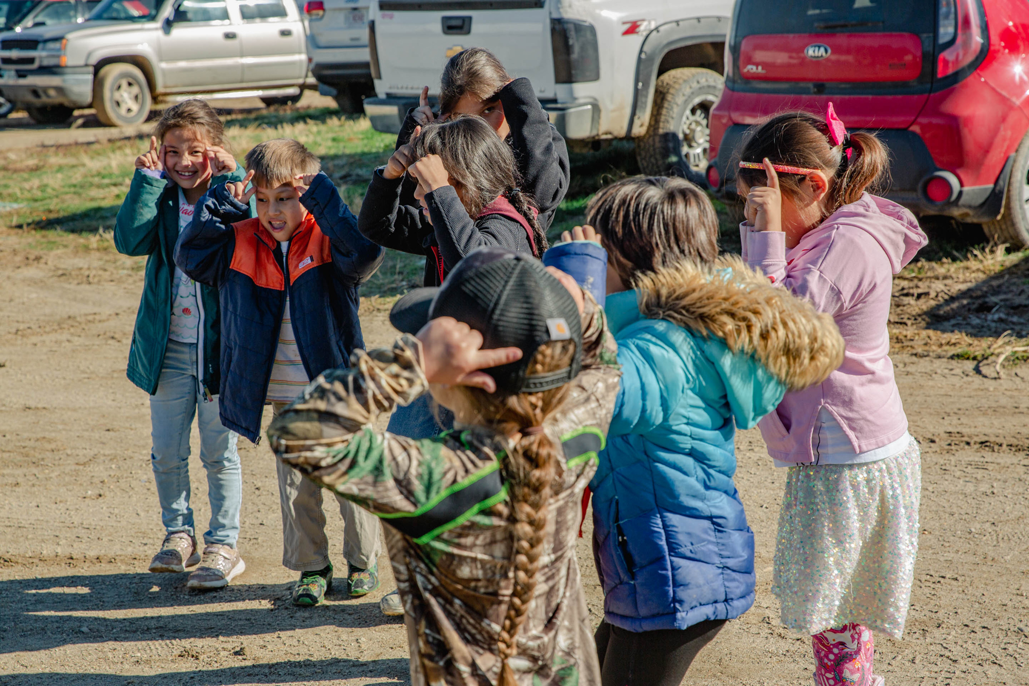 Children at the buffalo harvest laugh as they perform a buffalo dance together.