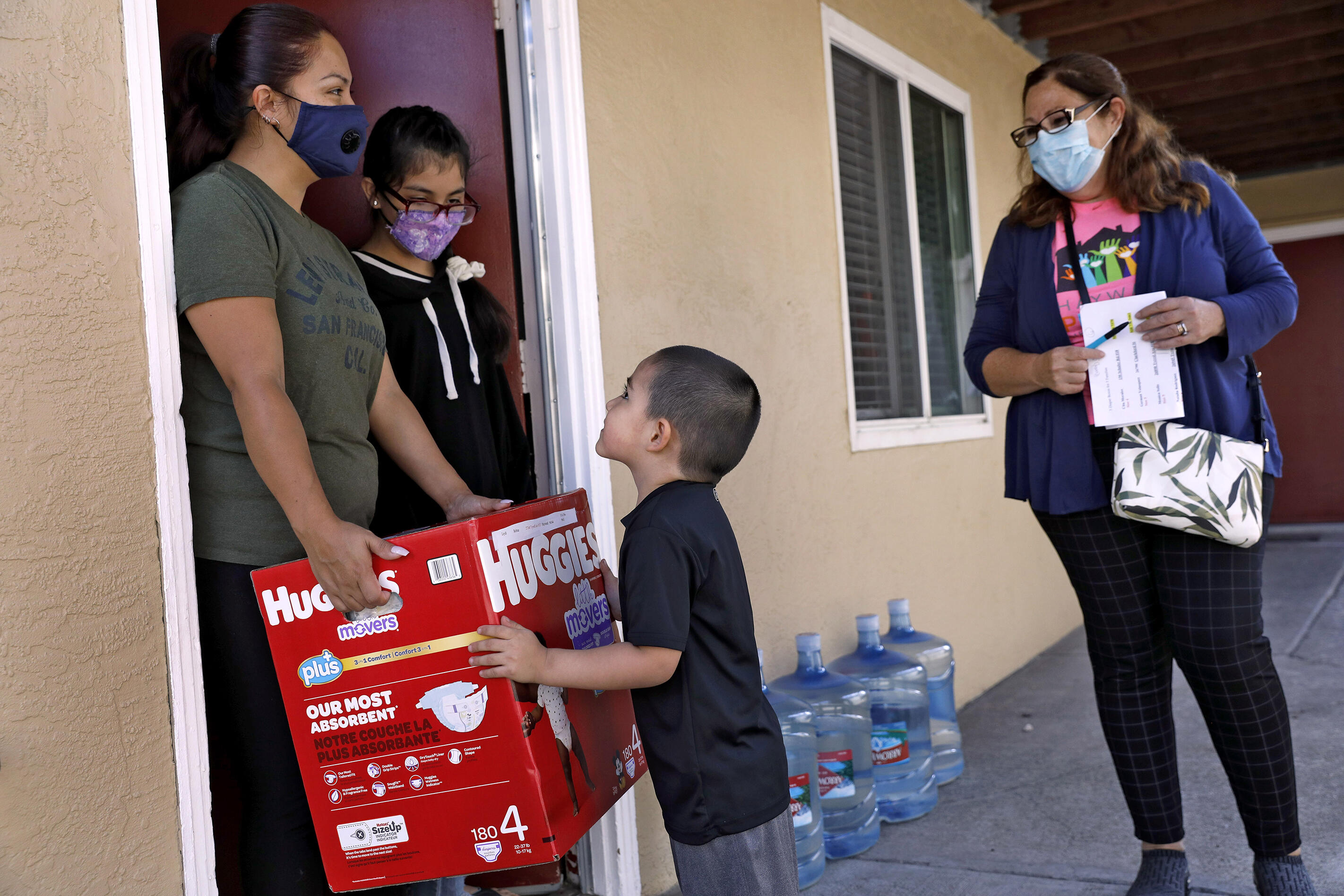 Promotora Nancy Respaldiza (right) delivers diapers and baby supplies to a family in Hayward, California. She and the other Promotores also shared information about the importance of participating in the 2020 Census with the families they visit. 