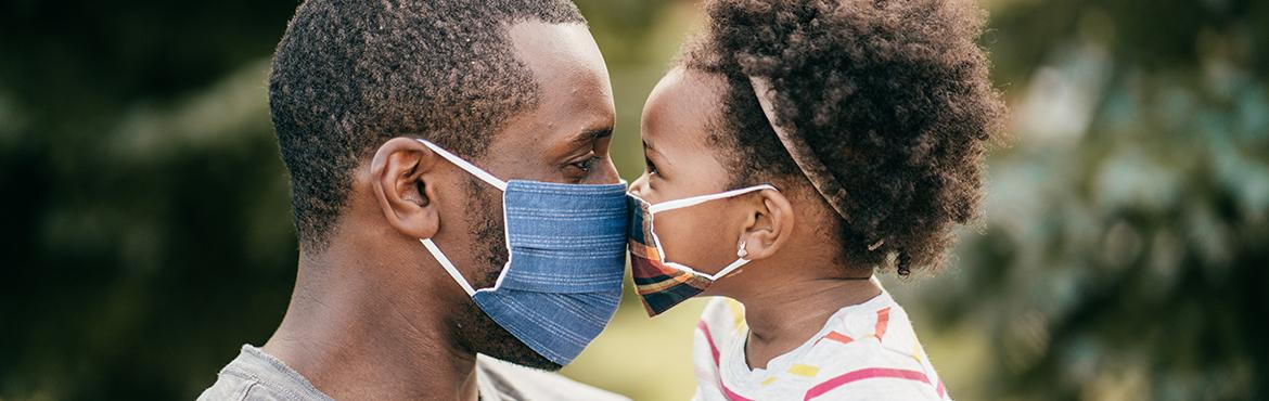 photo of parent and child wearing masks and putting faces together 