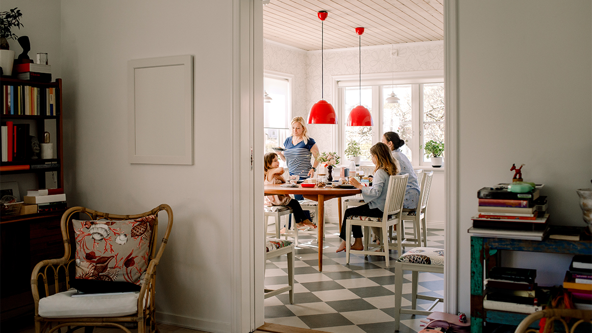 Photo of a mother and daughters having breakfast at a kitchen table.