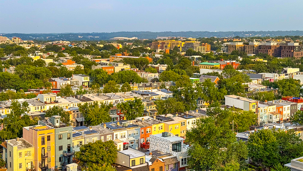 An image of the DC skyline with row houses and trees
