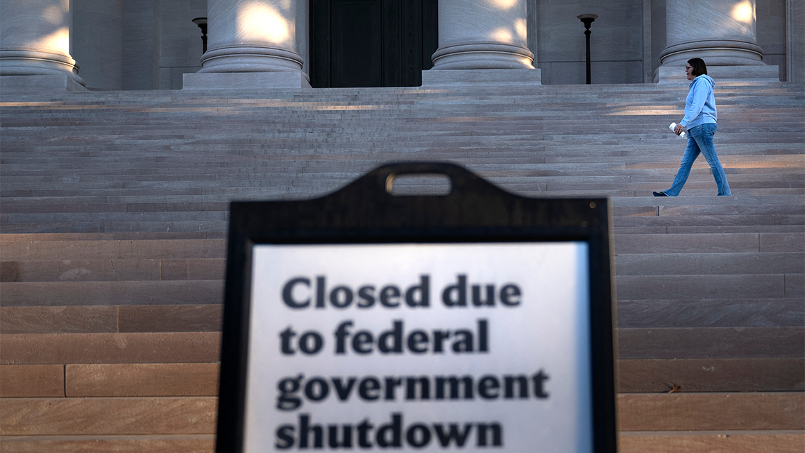 A woman walks past a sign indicating the National Gallery of Art is closed during the government shutdown