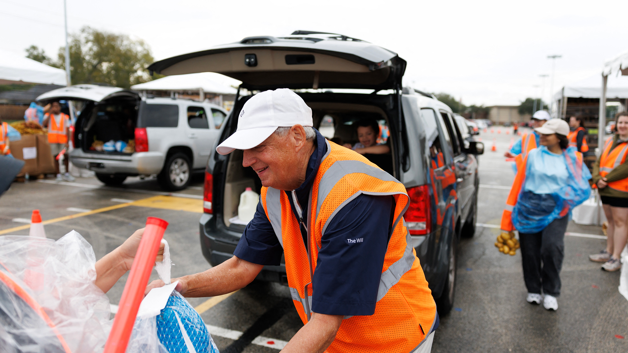 A volunteer hands out food at a food bank.