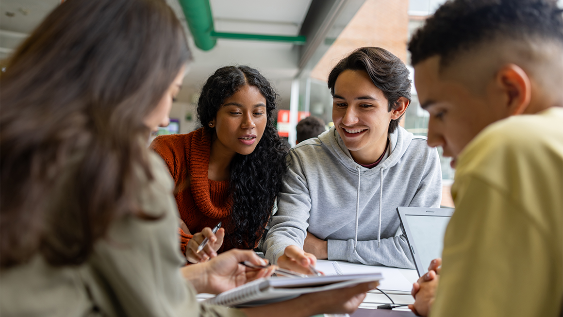 Four college-age students work on an assignment together at a table
