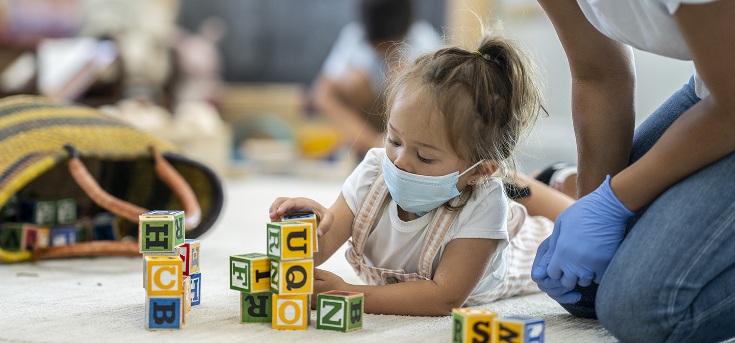 Child plays in a mask at day care