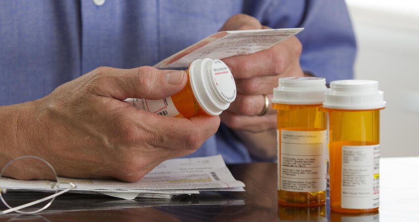 A person holding their prescription medications.