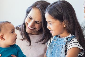 Multiethnic family playing with happy baby son at home