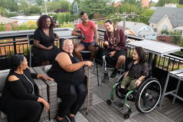 A group of women sitting while smiling