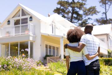 photo of couple in front of home