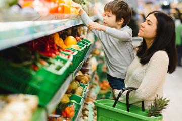 photo of woman and child during family shopping with trolley at supermarket