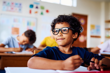 photo of young student sitting at desk in school