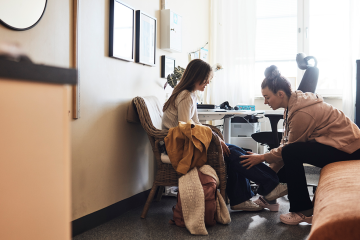 stock photo of physiotherapist examining leg of female student in school office