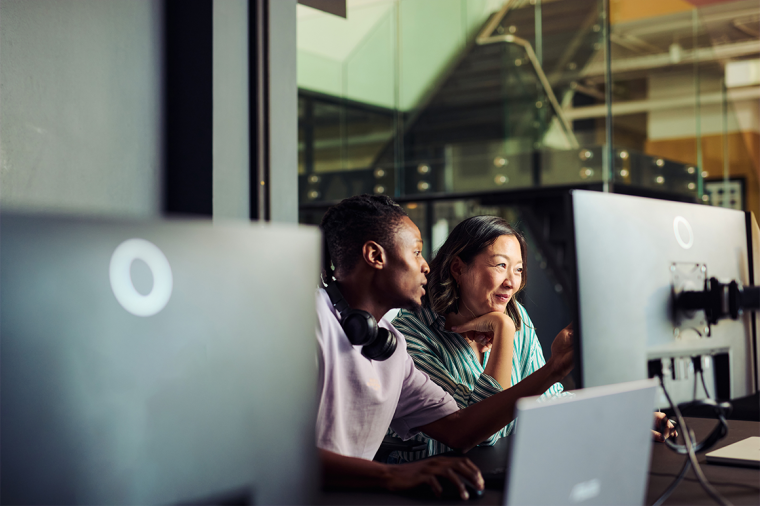 Programmers working together on a computer in office discussing a project - stock photo