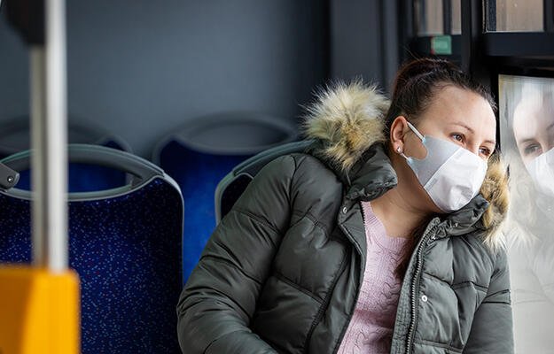 Woman rides bus wearing a mask