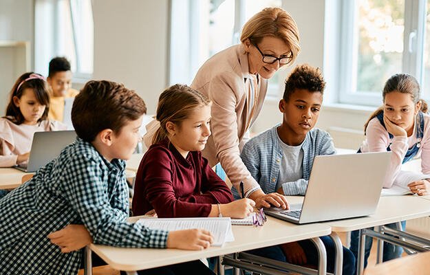 Children at school working on a laptop together