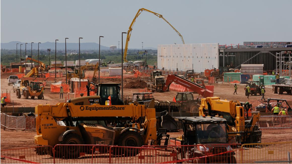 Construction site with heavy equipment and workers.