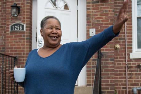 Woman waving in front of house