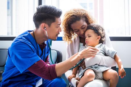A health care professional examining a child. 