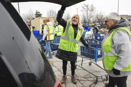 Northern Illinois Food Bank volunteers load a My Pantry Express order into the trunk of a car.