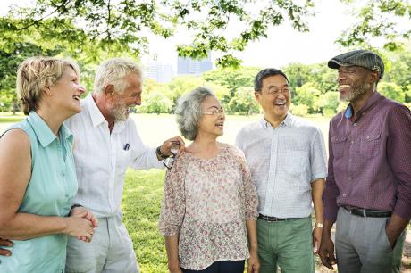 A group of older adults talking to each other outside.