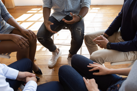photo of people seated in circle talking share problems tell stories