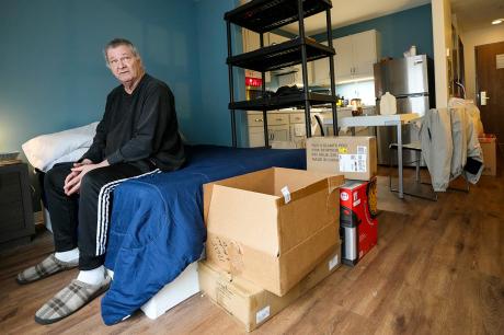 A man in a room with moving boxes. 