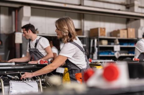 Several people work on machines in a factory
