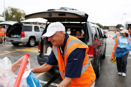 A volunteer hands out food at a food bank.