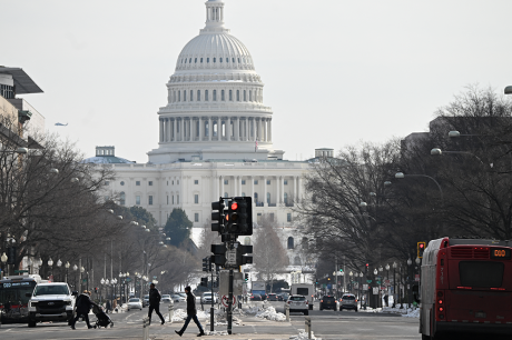 Photo of the Capitol building and a busy street on a gray winter day.
