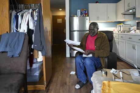 An Army veteran sits in his apartment looking at paperwork