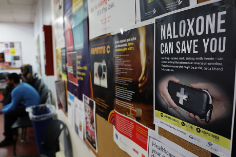 A sign for Naloxone hangs on a wall as students learn to put together a Naloxone spray gun in a class on opioid overdose prevention held by non-profit Positive Health Project on August 9, 2017 in New York City