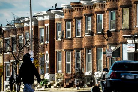 Row houses along a city street with a pedestrian crossing.