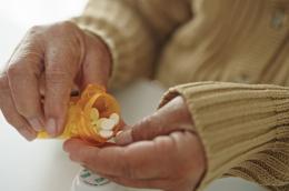 A person opens a pill bottle