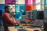 A professional working in front of multiple computer screens.