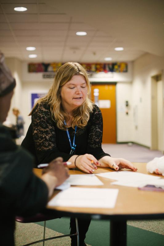 Shellie Rowe, family centers manager at Neighborhood House, explains intake paperwork at the organization’s Crisis Mornings service.