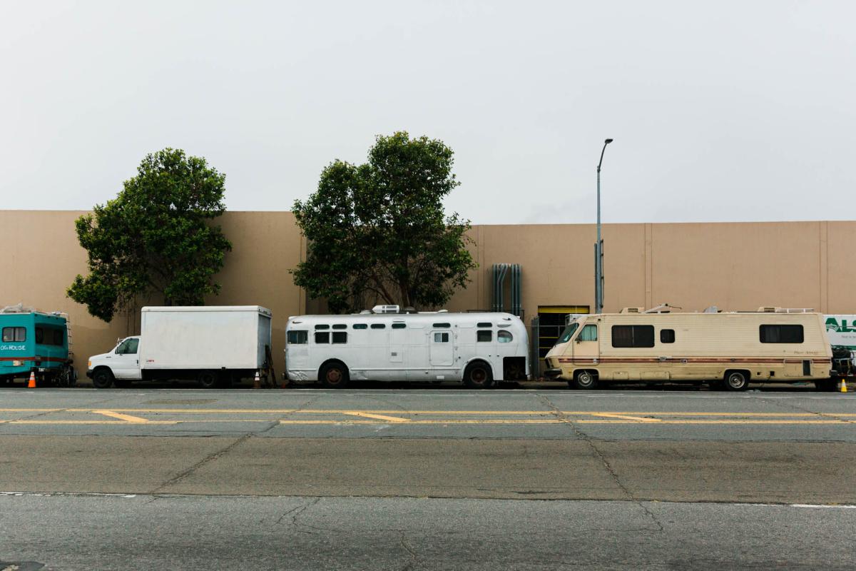 A row of camper vans, trailers, and box trucks where people experiencing homelessness live are parked in the Bayview neighborhood in southeastern San Francisco.