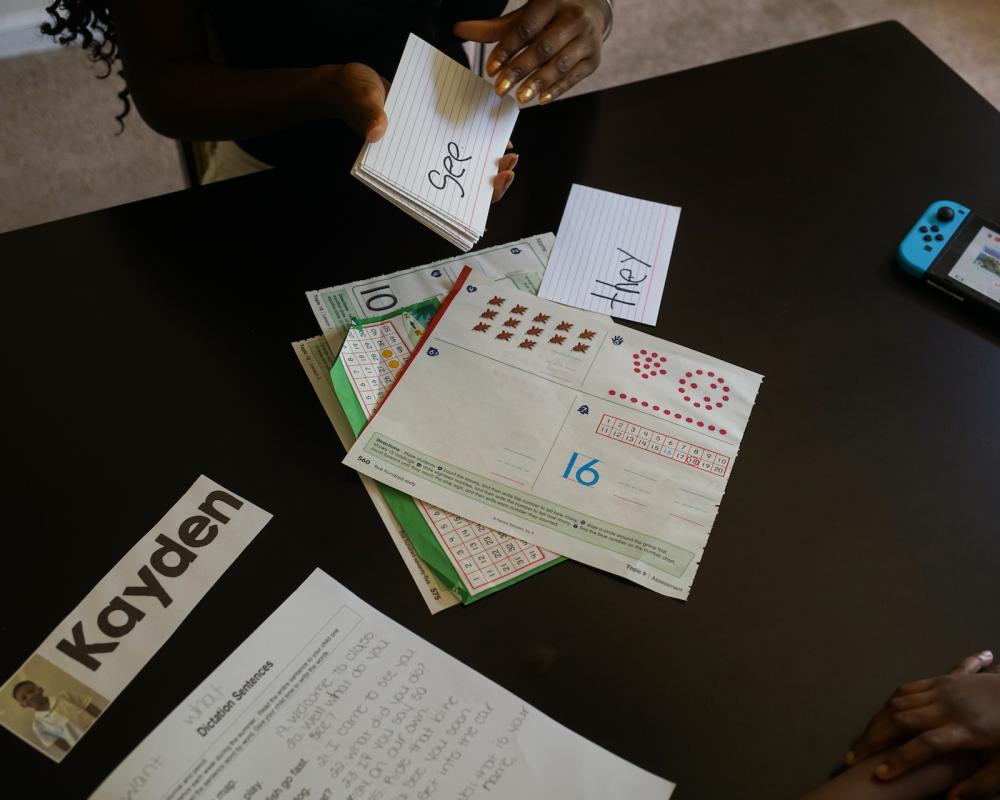 Gina Jackson holds up flash cards to help her son, Kayden, practice new vocabulary words. 